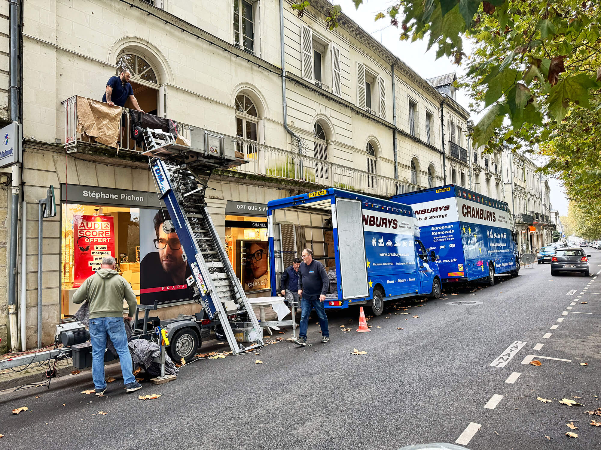 Cranburys European Removals team loading furniture into a vehicle using an external elevator in a French city centre